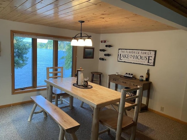 dining room with a water view, carpet flooring, and wood ceiling