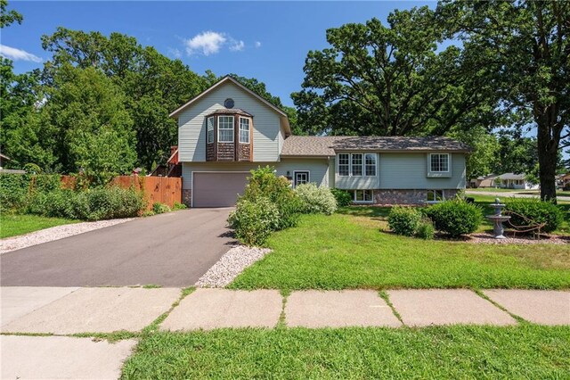 split level home with a garage and a front lawn