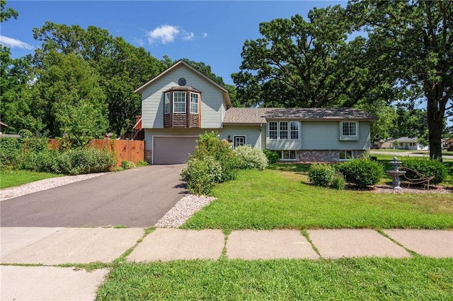 tri-level home with a garage and a front lawn