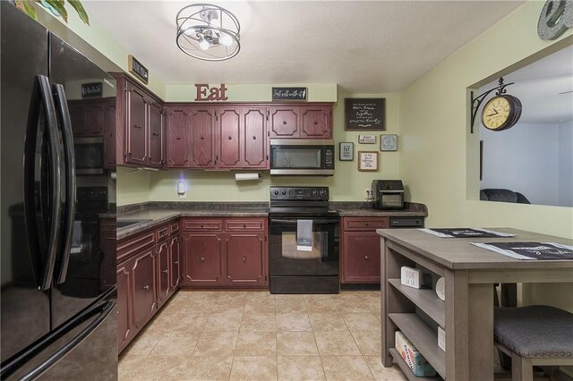 kitchen with light tile patterned flooring and black appliances