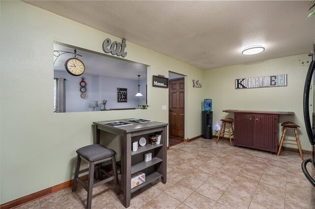 kitchen with pendant lighting, a textured ceiling, and light tile patterned floors