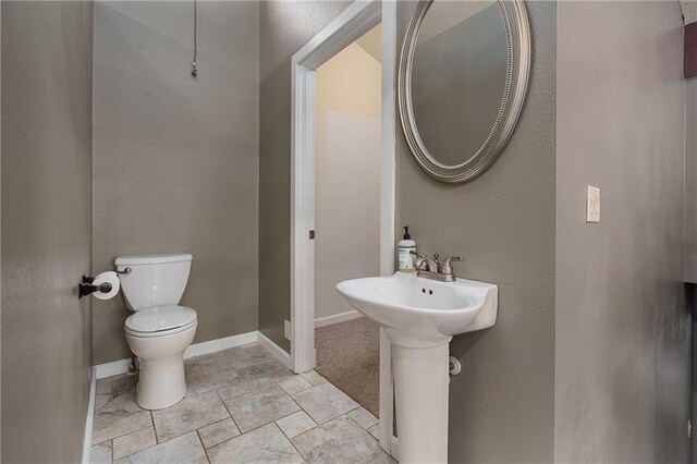 bathroom with toilet and tile patterned floors