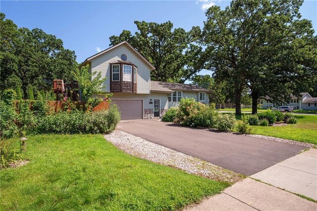 view of front of house with a garage and a front lawn