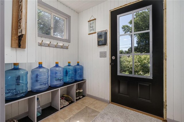 mudroom featuring light tile patterned flooring and wooden walls