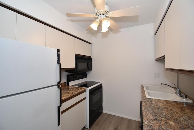 kitchen with white cabinetry, sink, and black appliances