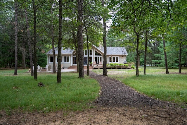 view of front of property with a wooden deck and a front lawn