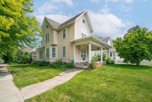 view of front of house with covered porch and a front lawn