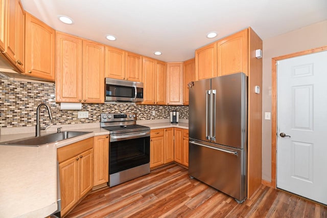 kitchen with dark wood-type flooring, backsplash, stainless steel appliances, and sink