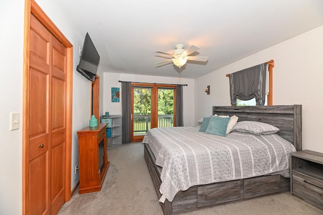 bedroom with access to outside, ceiling fan, light colored carpet, and a closet