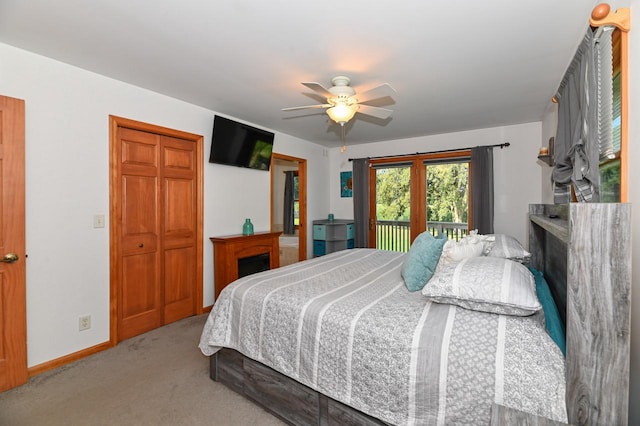 carpeted bedroom with access to exterior, ceiling fan, and a closet