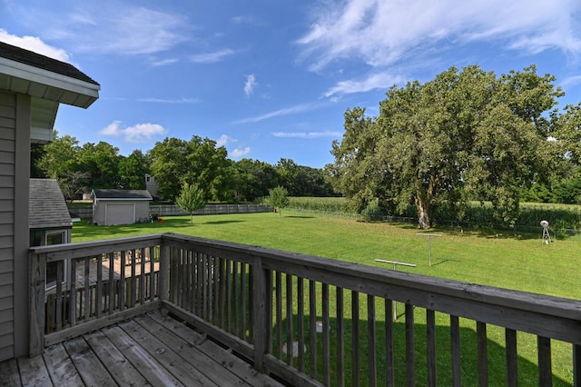 wooden terrace featuring a storage shed and a lawn