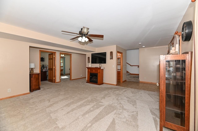 unfurnished living room with light colored carpet and ceiling fan