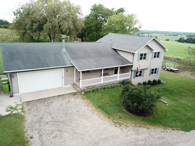 view of front of house featuring a porch, a garage, and a front yard