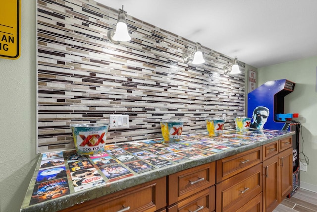 bar featuring tasteful backsplash, decorative light fixtures, and light hardwood / wood-style floors