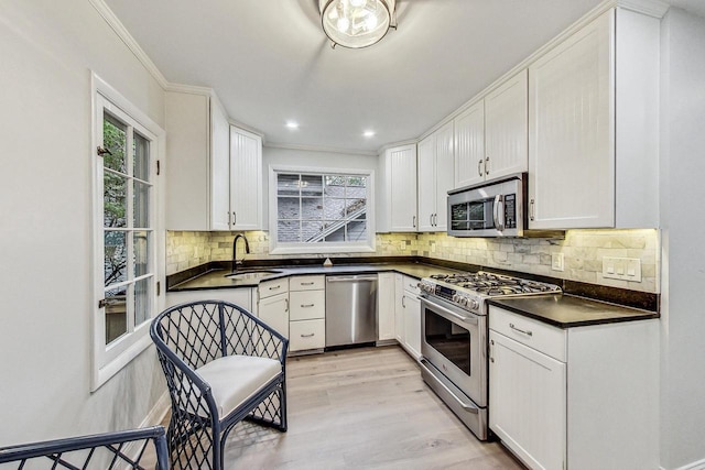 kitchen with light hardwood / wood-style flooring, sink, stainless steel appliances, and white cabinets