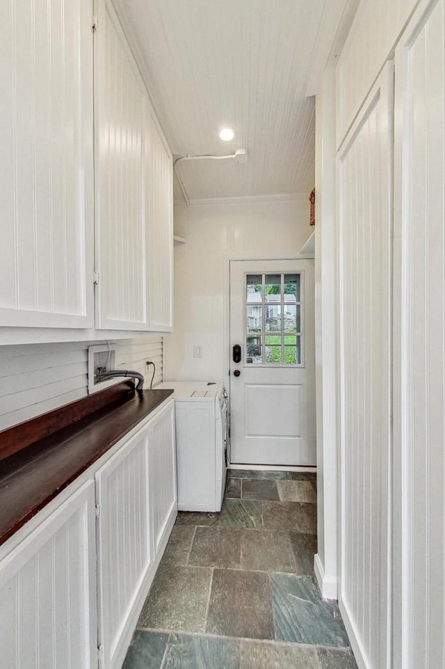 washroom with cabinets, dark tile patterned floors, washer and clothes dryer, and ornamental molding