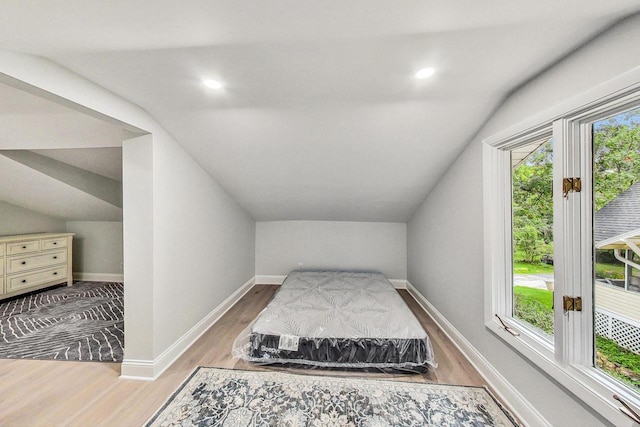 interior space with light wood-type flooring and vaulted ceiling