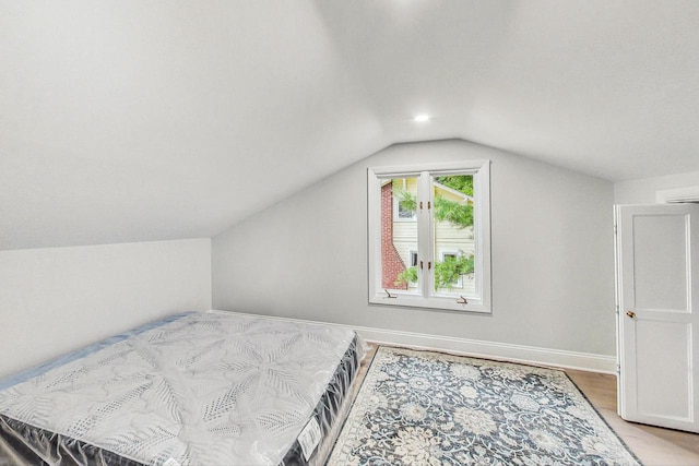 bedroom with lofted ceiling and hardwood / wood-style flooring