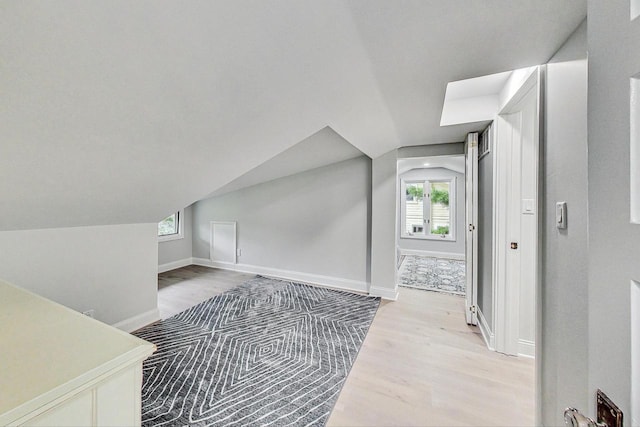 additional living space featuring lofted ceiling and light wood-type flooring