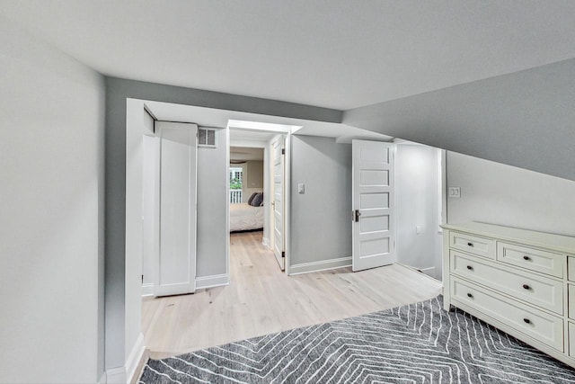 interior space with light hardwood / wood-style flooring and vaulted ceiling