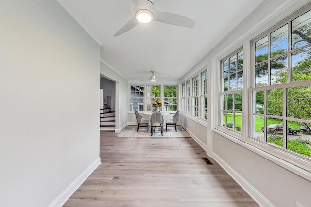 unfurnished sunroom with ceiling fan and a wealth of natural light