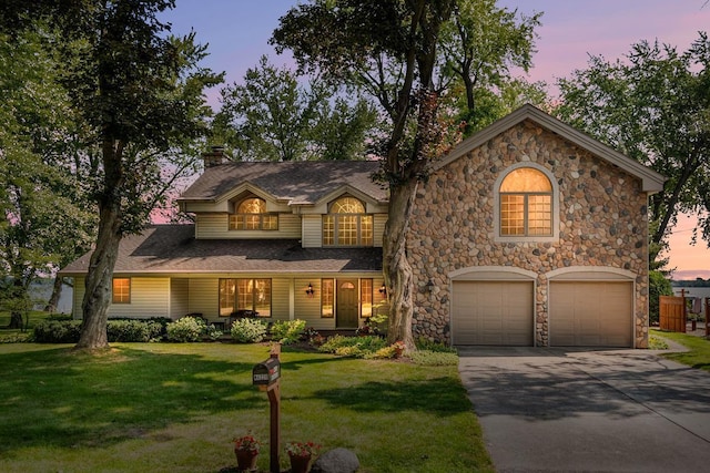 view of front of house featuring a garage and a yard