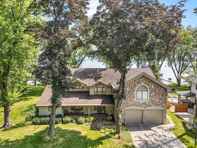 view of front of house featuring a garage, a front yard, and covered porch