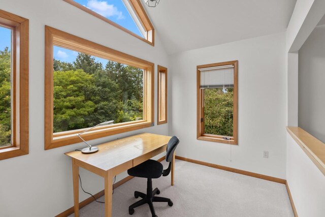 carpeted office space featuring vaulted ceiling and a healthy amount of sunlight