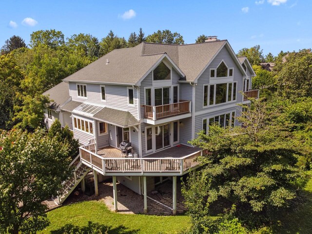 back of house with a wooden deck and a balcony