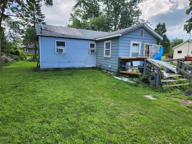 rear view of property featuring a yard and a deck