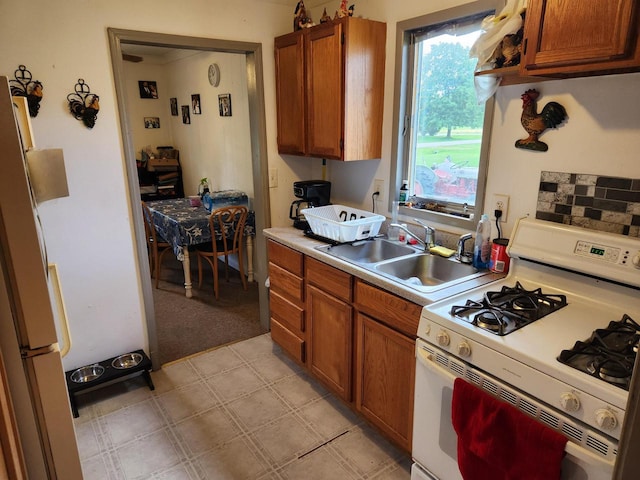 kitchen featuring sink, white appliances, and light tile patterned floors