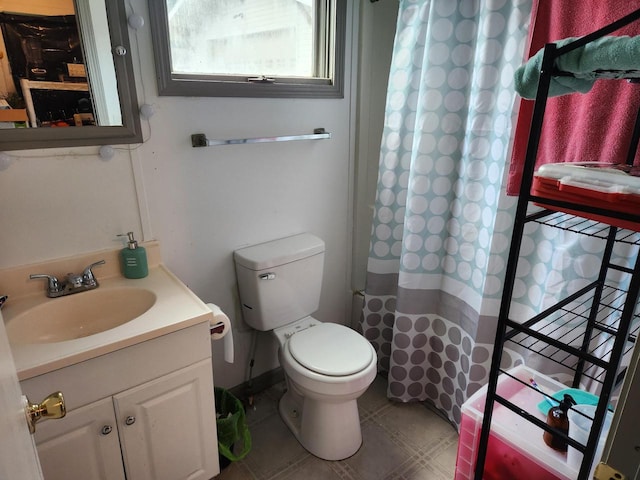 bathroom with toilet, vanity, and tile patterned flooring