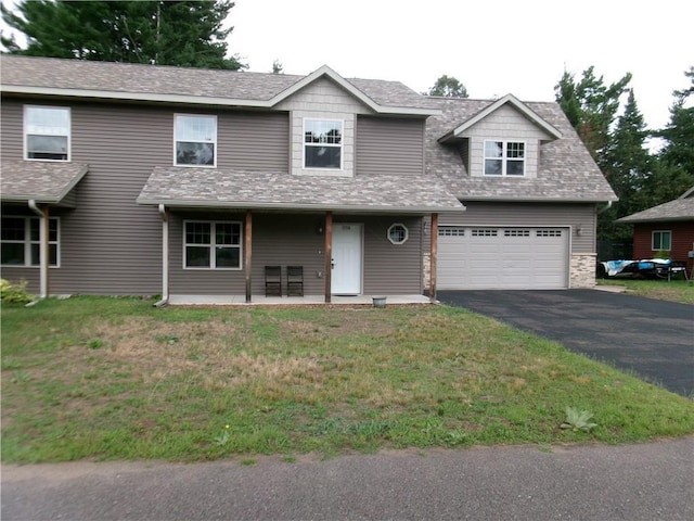 15716 Logan Ln, Hayward, WI 54843 - view of front of home with aphalt driveway, a garage, a front yard, and a shingled roof
