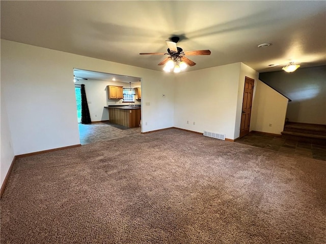 unfurnished living room featuring ceiling fan and carpet floors