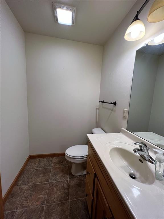 bathroom with toilet, tile patterned floors, and vanity