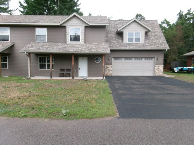 15716 Logan Ln, Hayward, WI 54843 - view of front facade featuring a garage, a front lawn, driveway, and a shingled roof
