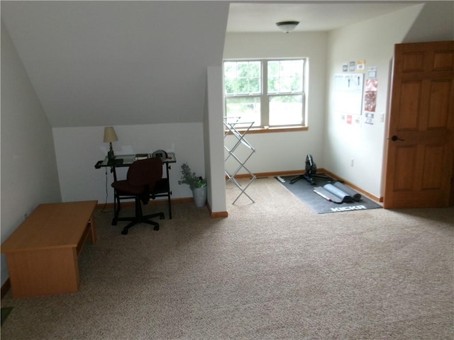 carpeted home office featuring vaulted ceiling