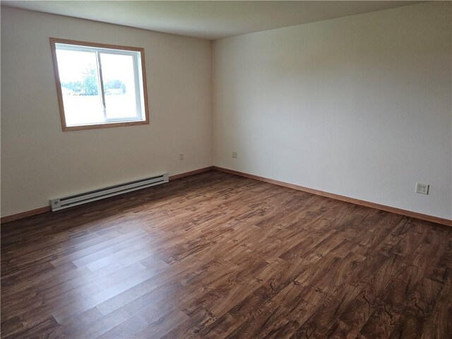 unfurnished room featuring a baseboard heating unit and dark wood-type flooring
