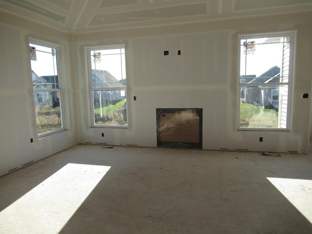 unfurnished living room with a fireplace and a wealth of natural light