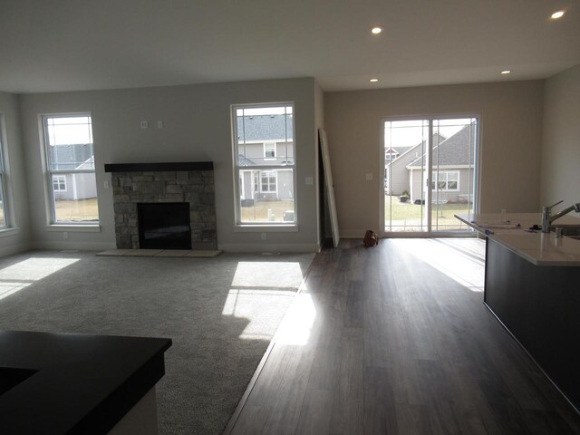 518 Woodside Ct, West Bend, WI 53095 - living room with recessed lighting, a stone fireplace, a healthy amount of sunlight, and wood finished floors