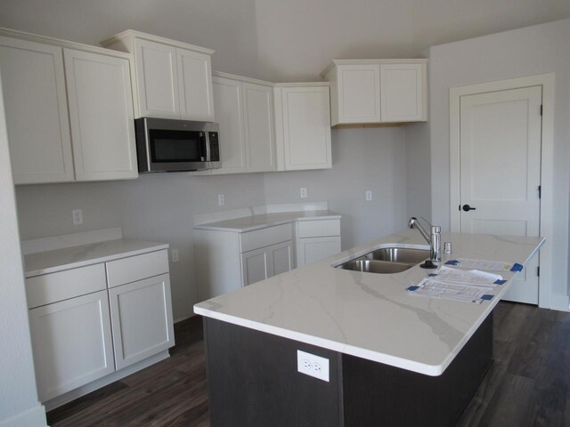 518 Woodside Ct, West Bend, WI 53095 - kitchen featuring a sink, stainless steel microwave, dark wood-type flooring, a center island with sink, and white cabinetry