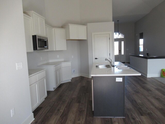 518 Woodside Ct, West Bend, WI 53095 - kitchen with a sink, white cabinets, an island with sink, stainless steel microwave, and dark wood-type flooring