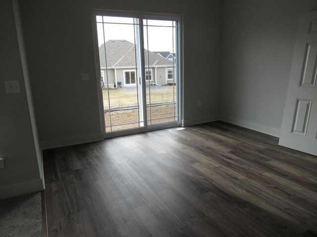 518 Woodside Ct, West Bend, WI 53095 - spare room featuring baseboards and dark wood-type flooring