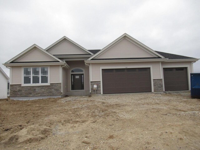 518 Woodside Ct, West Bend, WI 53095 - craftsman-style house with stone siding, an attached garage, and driveway