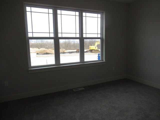 518 Woodside Ct, West Bend, WI 53095 - spare room with dark carpet, baseboards, and visible vents