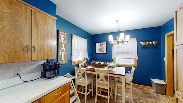 kitchen with pendant lighting, tasteful backsplash, a notable chandelier, and sink