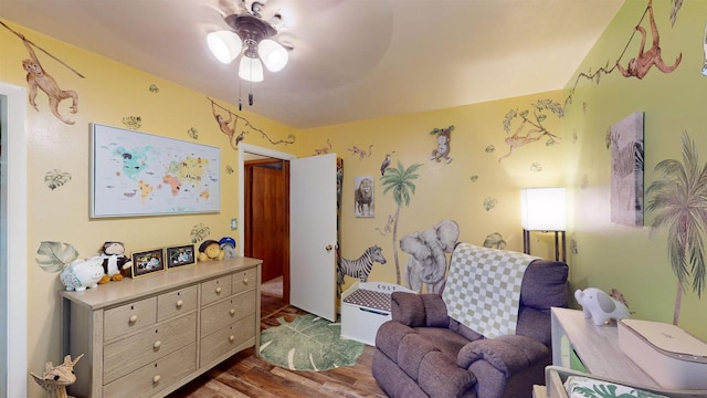 sitting room featuring dark hardwood / wood-style floors and ceiling fan