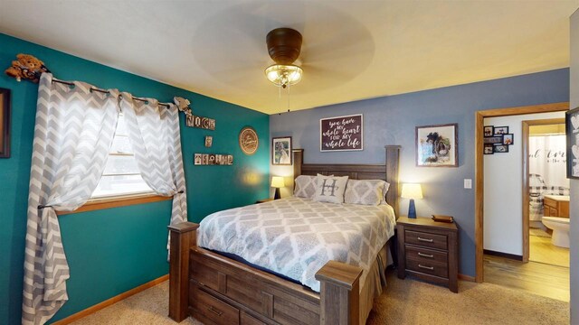 bedroom with light carpet, ensuite bath, and ceiling fan