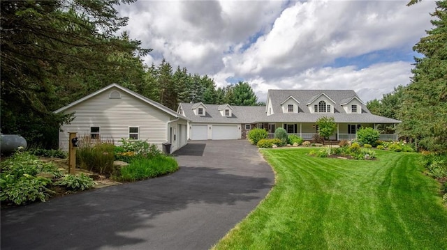 new england style home featuring a garage and a front lawn