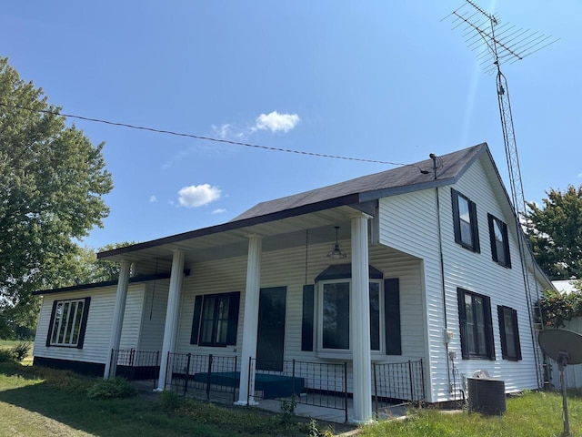 view of home's exterior with covered porch and cooling unit